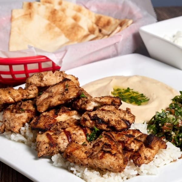 ShouFi MahFi Mediterranean Grill's grilled chicken over rice with hummus, tabbouleh, and pita bread.