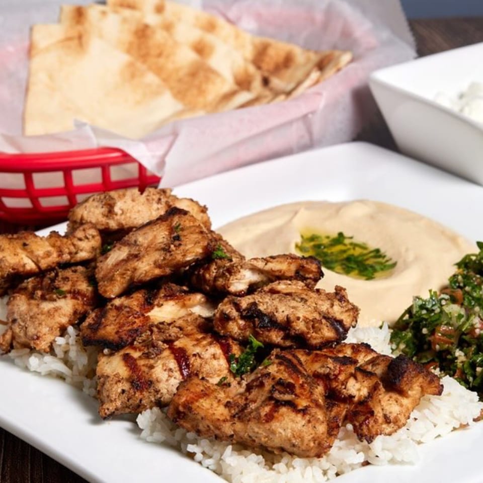 ShouFi MahFi Mediterranean Grill's grilled chicken over rice with hummus, tabbouleh, and pita bread.