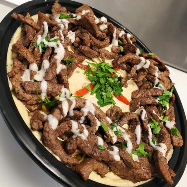 ShouFi MahFi Mediterranean Grill's shawarma platter with meat, hummus, parsley, and white sauce.